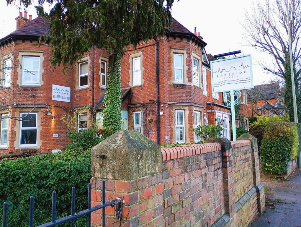 a brick building with a brick fence in front of it at Lakeside Oxford Hotel in Oxford