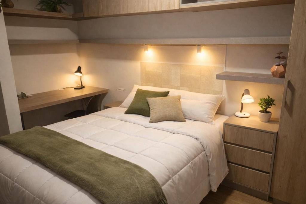 Schlafzimmer mit einem Bett, einem Schreibtisch und Lampen in der Unterkunft Moderno y cómodo estudio con espacio de trabajo in Cochabamba
