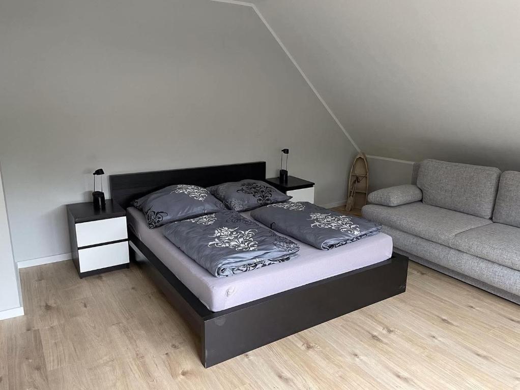 a bedroom with a bed and a couch at Ferienwohnung Bayside in Edertal