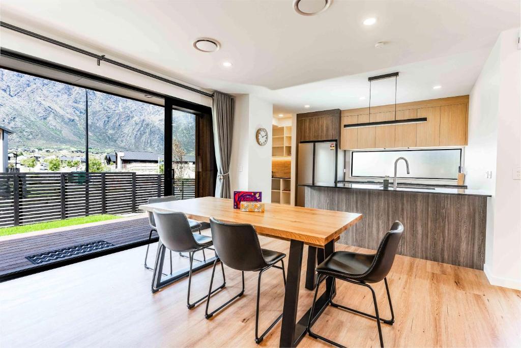 a kitchen and dining room with a wooden table and chairs at Remarkable Cross Road Retreat in Frankton