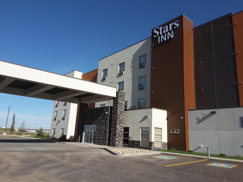 a hotel with a sign on the side of a building at Stars Inn in Leduc