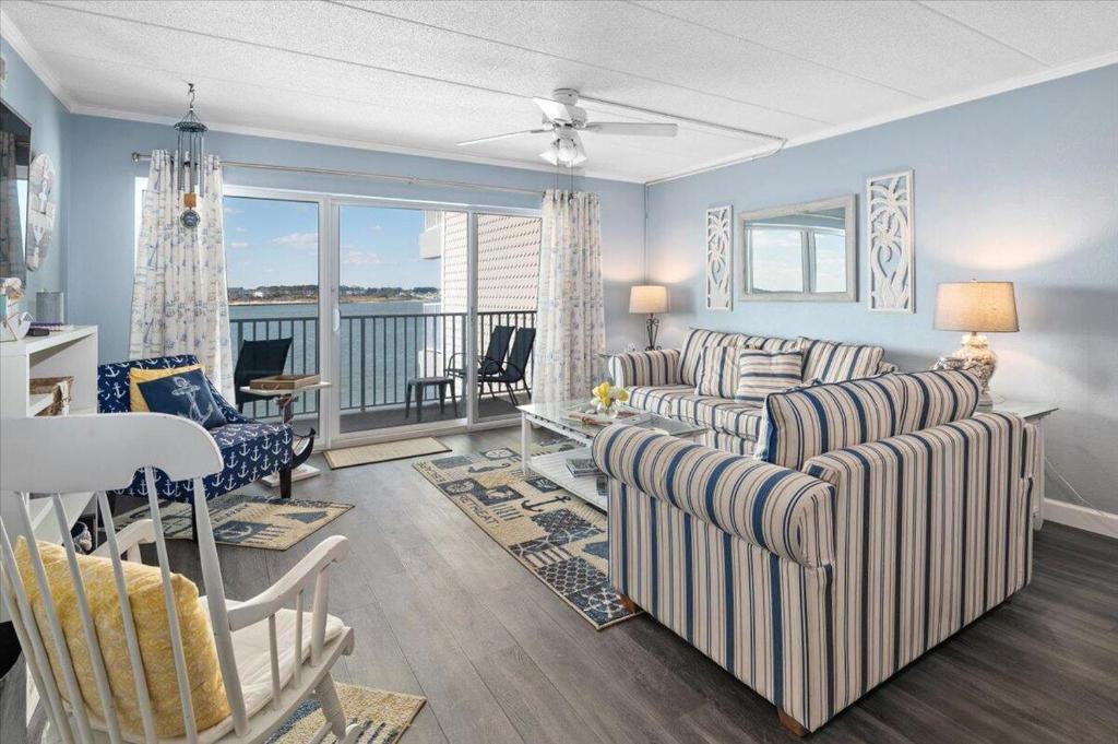 a living room with two couches and a balcony at One of a Kind Direct Bay Views From This 3 Bedroom Condo With Pool! in Ocean City