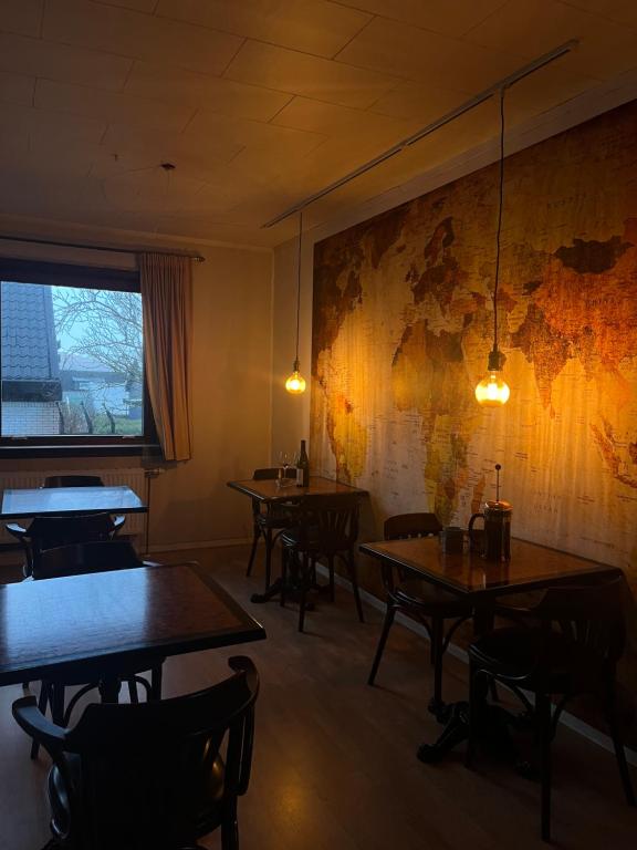 a restaurant with tables and chairs and a map on the wall at Guesthouse Leon in Tórshavn