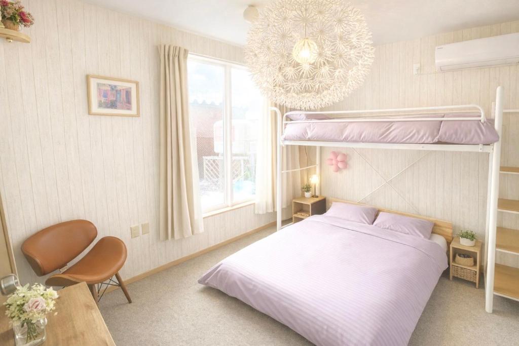 een slaapkamer met een stapelbed en een kroonluchter bij Yume House in Furano
