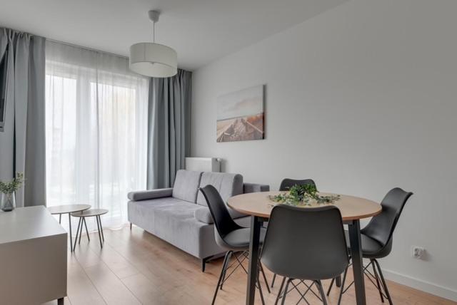 un soggiorno con un divano, un tavolo e delle sedie di Trimare Seaside Apartment a Sztutowo