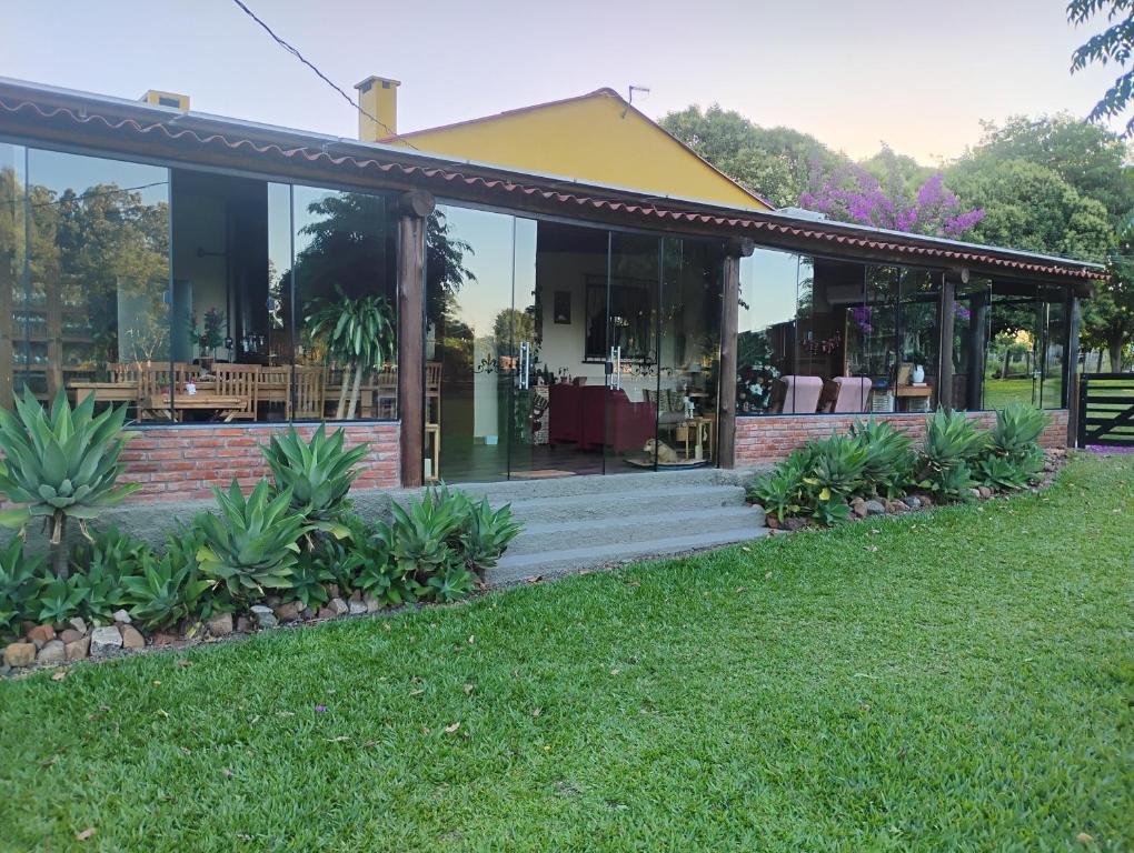 een huis met glazen deuren en een gazon bij Chácara Alci Guedes in São Gabriel