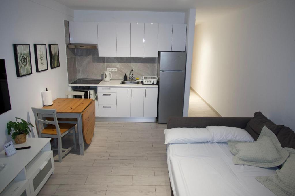 eine Küche mit einer Couch und einem Tisch in einem Zimmer in der Unterkunft ¡Tal y como Hawaii! in Playa Fañabe