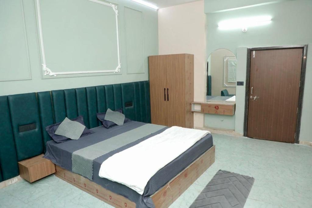 ein Schlafzimmer mit einem großen Bett und einem Spiegel in der Unterkunft Premium Place in Chittaurgarh