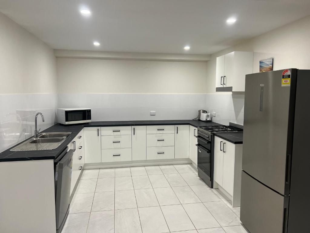 Streaky BayBeachside & Jetty View 3 - Pirate Cave No view的配有白色橱柜和不锈钢冰箱的厨房