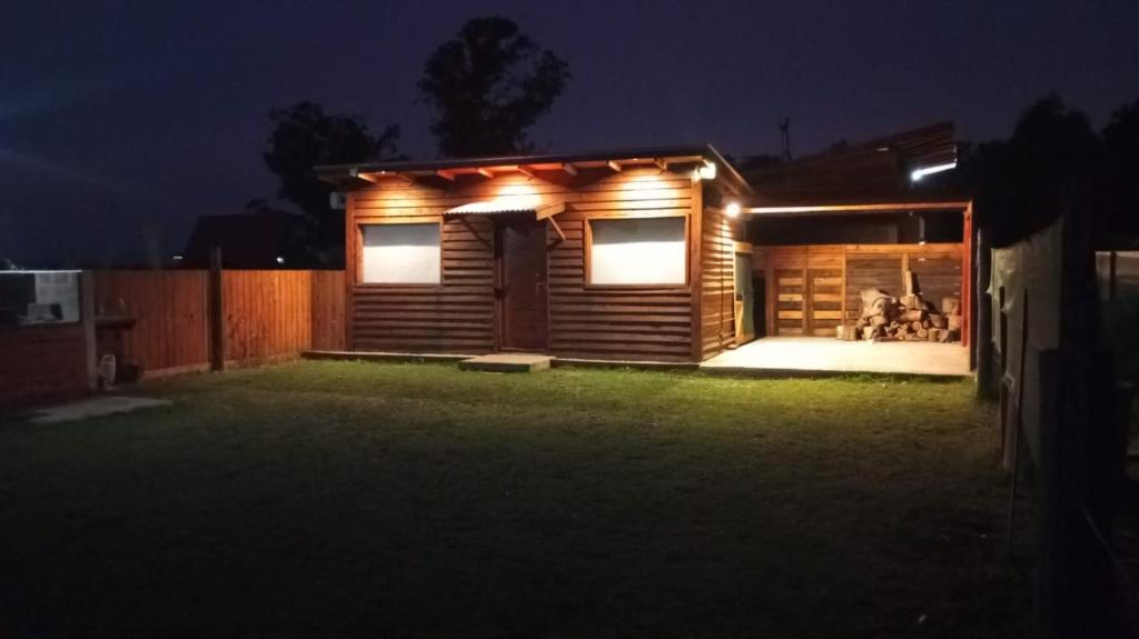 una piccola casa con le luci accese di notte di Cabaña El Atardecer 2 a Necochea
