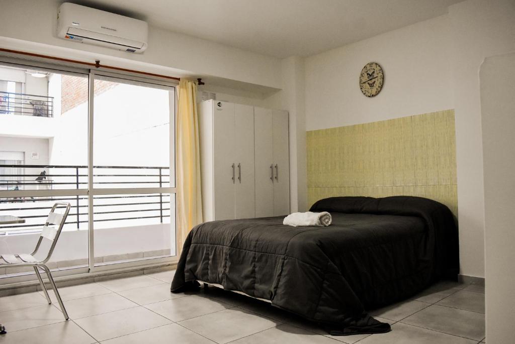 a bedroom with a bed and a clock on the wall at Loft Rio - Ideal turismo - Opcion a cochera! in Rosario