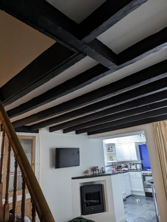 a living room with a ceiling with black beams at Neifion in Aberdyfi