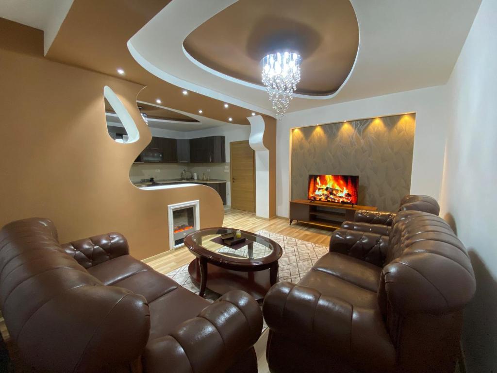 ein Wohnzimmer mit Ledermöbeln und Kamin in der Unterkunft Apartment Gostivar in Gostivar