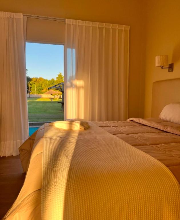 a bedroom with two beds and a large window at Complejo Bohio Hotel Boutique in Lobos