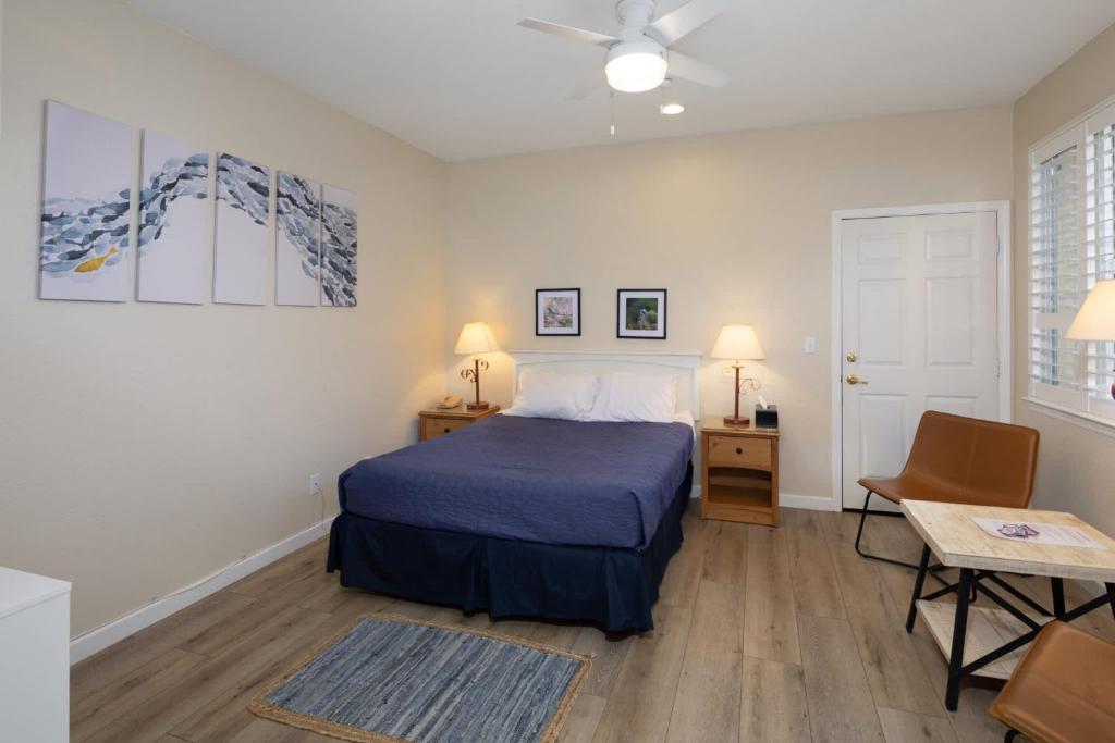 a bedroom with a bed and a table and a chair at Coastal Glow in Oceano