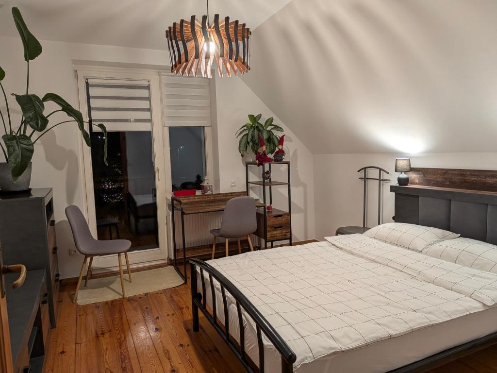 Un dormitorio con una cama y una mesa y sillas. en Apartament Forest, en Mysłakowice