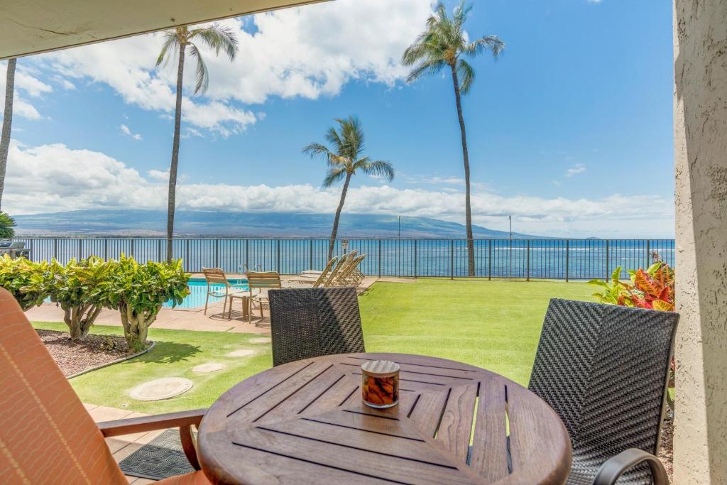 een houten tafel met een kopje koffie op een patio bij Lauloa 102 in Wailuku