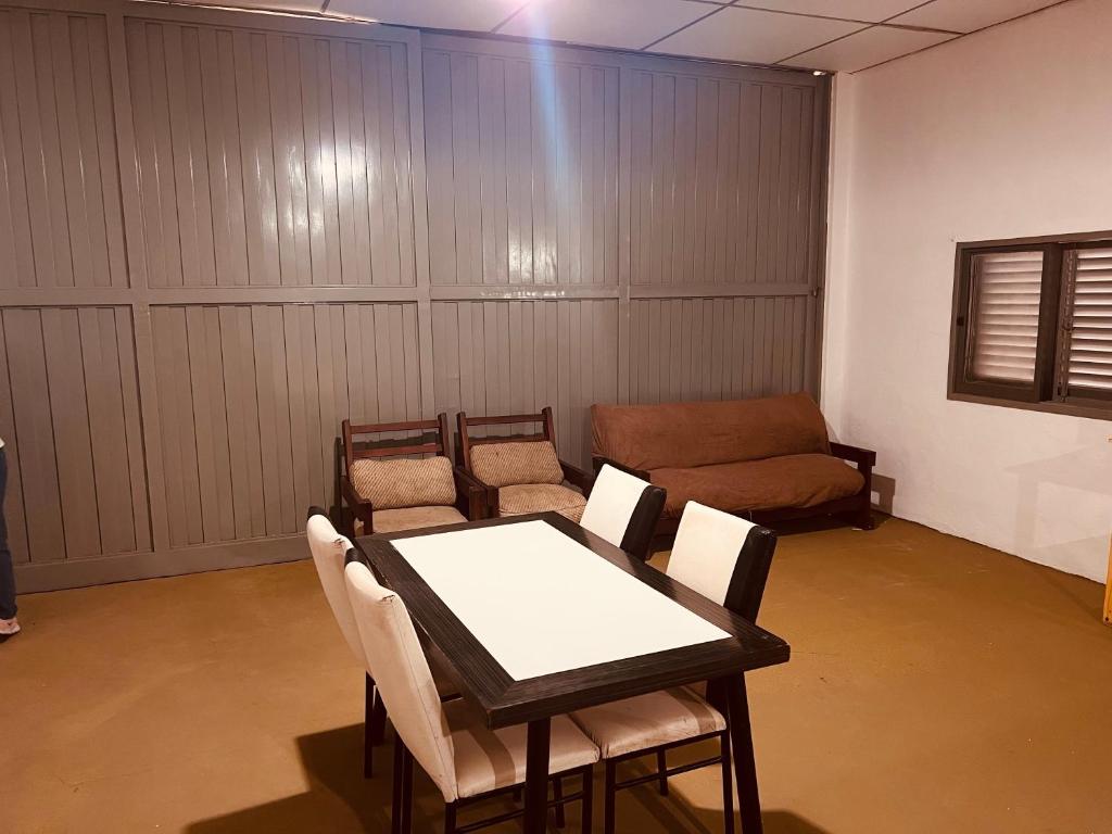 een kamer met een tafel, stoelen en een bank bij Doma y folklore in Colonia Caroya