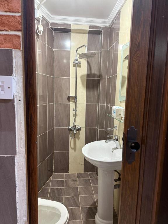 Un baño con lavabo, inodoro y ducha. en ماي سويت, en Kuwait