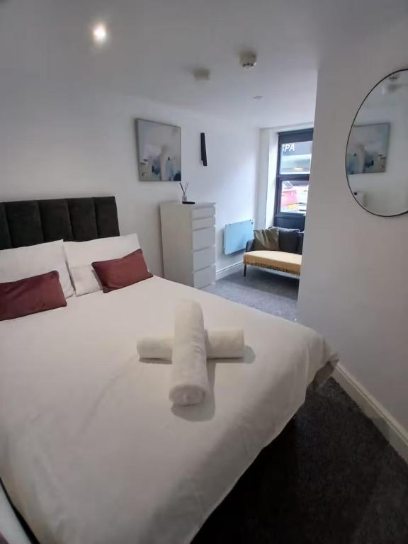 a bedroom with a large white bed with towels on it at Elegant Broadway Retreat w Parking & Dog Friendly in Broadway