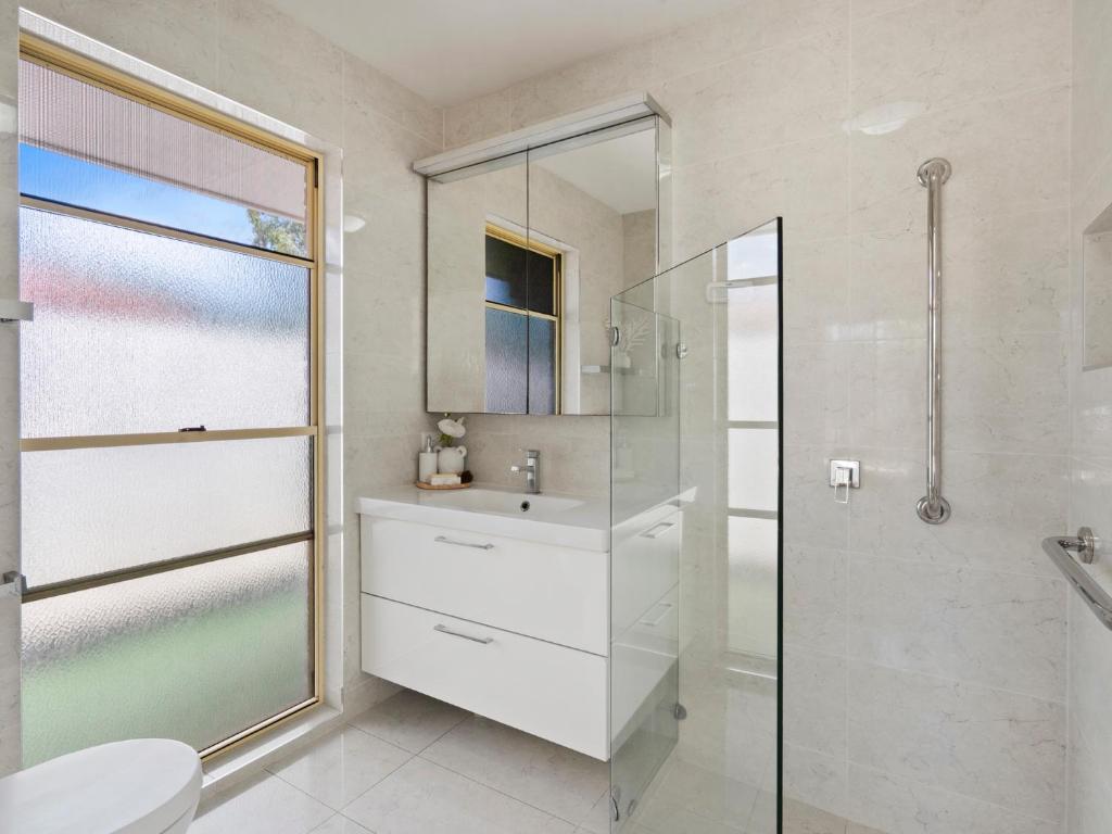 ein Badezimmer mit Glasdusche und Waschbecken in der Unterkunft Cabarita Barefoot Beach House in Cabarita Beach