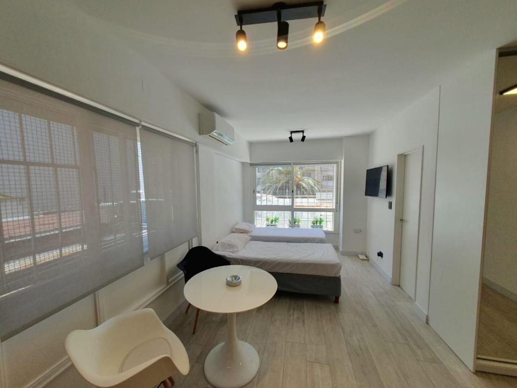 een slaapkamer met een bed, een tafel en stoelen bij Viamonte Che! in Buenos Aires