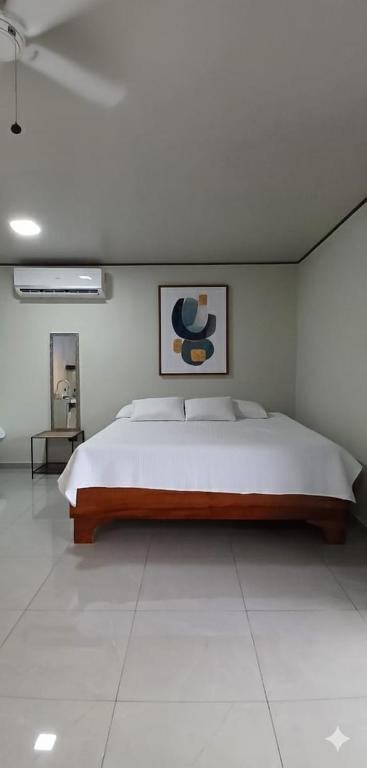 a bedroom with a large bed in a white room at Apartamentos Jireh in Quepos