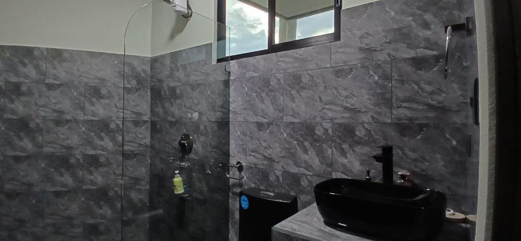 un bagno con un lavandino nero e una doccia di Apartamentos Jireh a Quepos