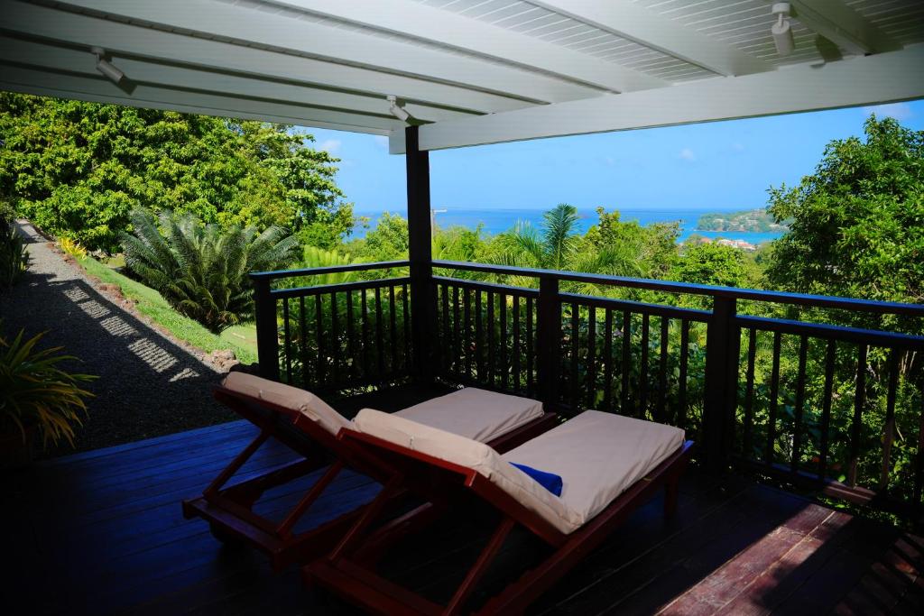 a deck with two lounge chairs on a balcony at Memwa Villas in Castries