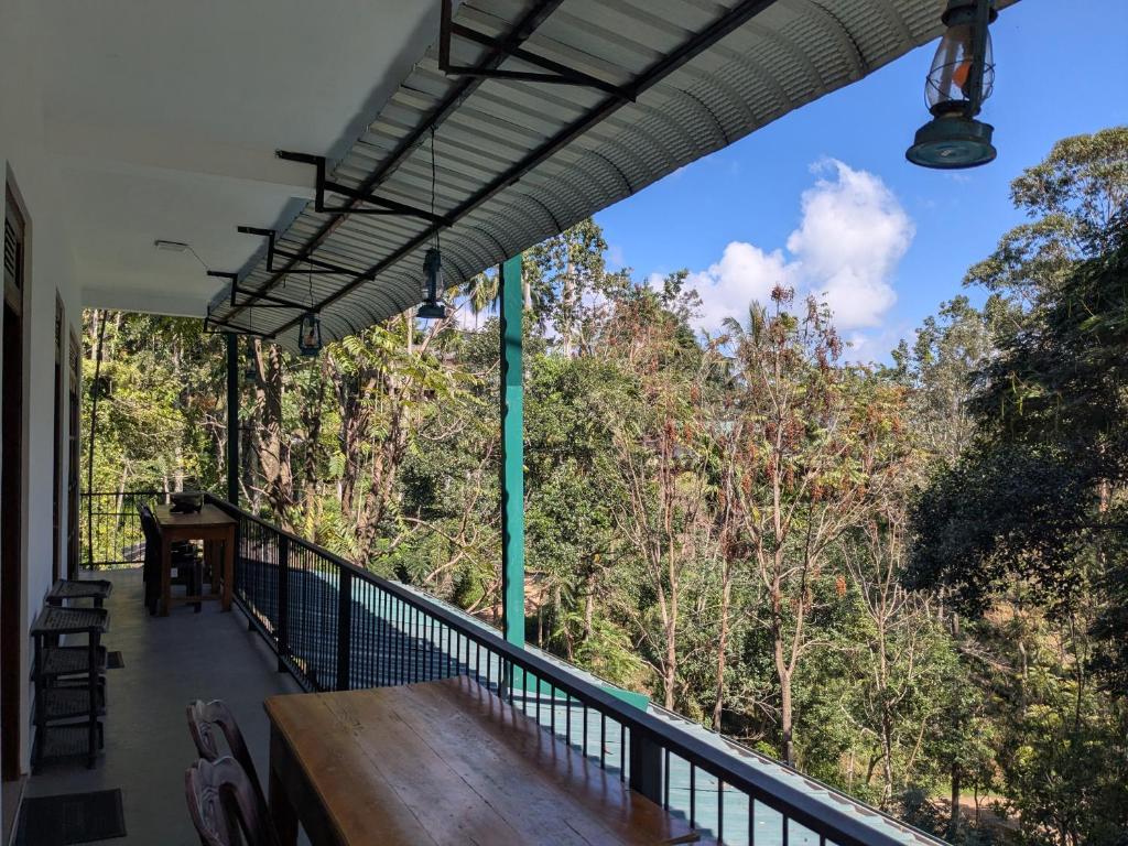a balcony with a table and a view of trees at Ella South Star in Ella
