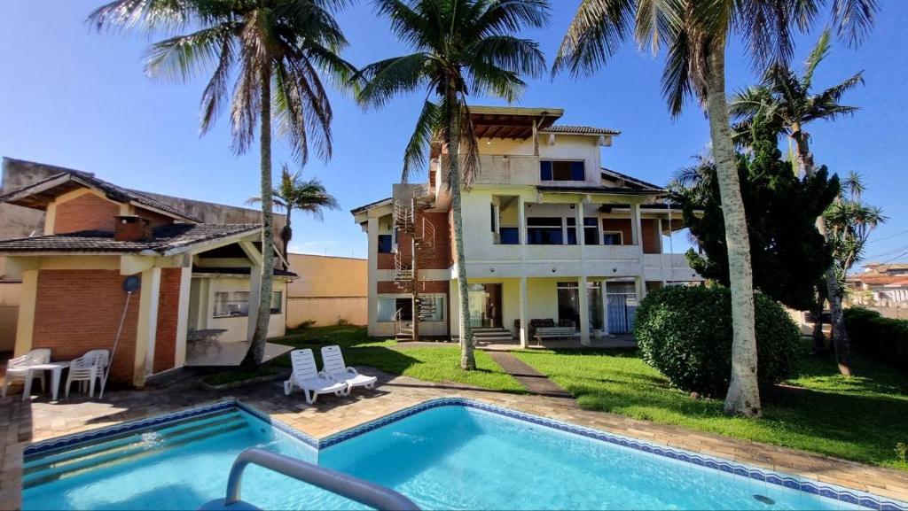 ein Haus mit einem Swimmingpool vor dem Haus in der Unterkunft Casa da praia pousada in Peruíbe