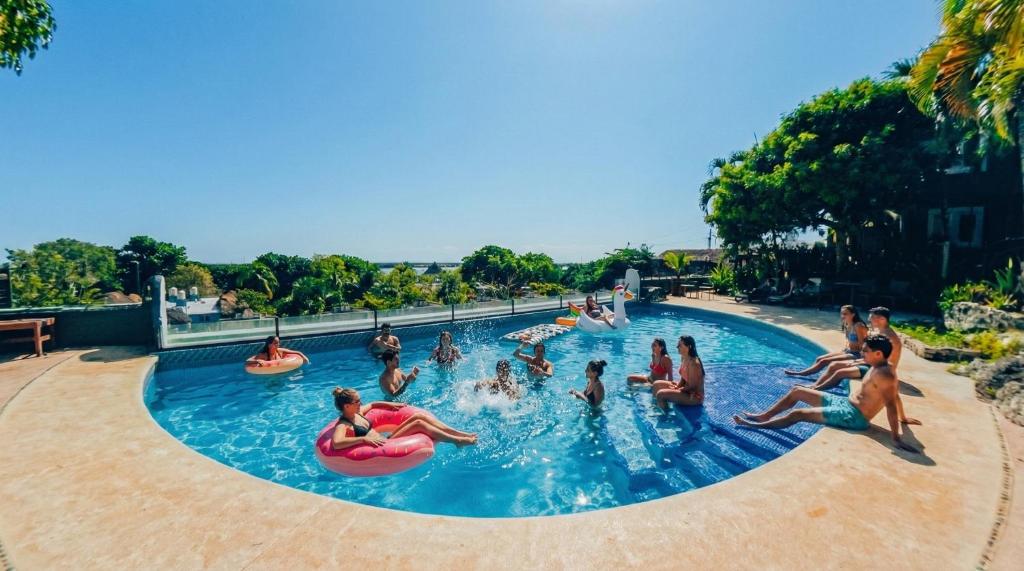 eine Gruppe von Menschen in einem Schwimmbad in der Unterkunft Viajero Bacalar Hostel in Bacalar