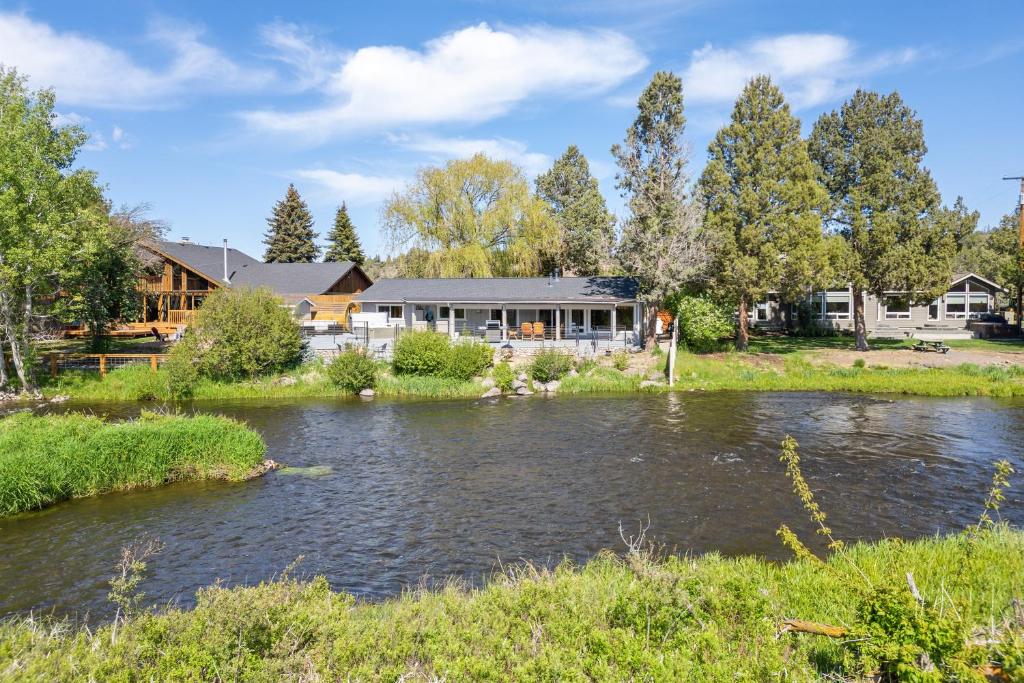 a house with a river in front of it at Otter Run in Bend