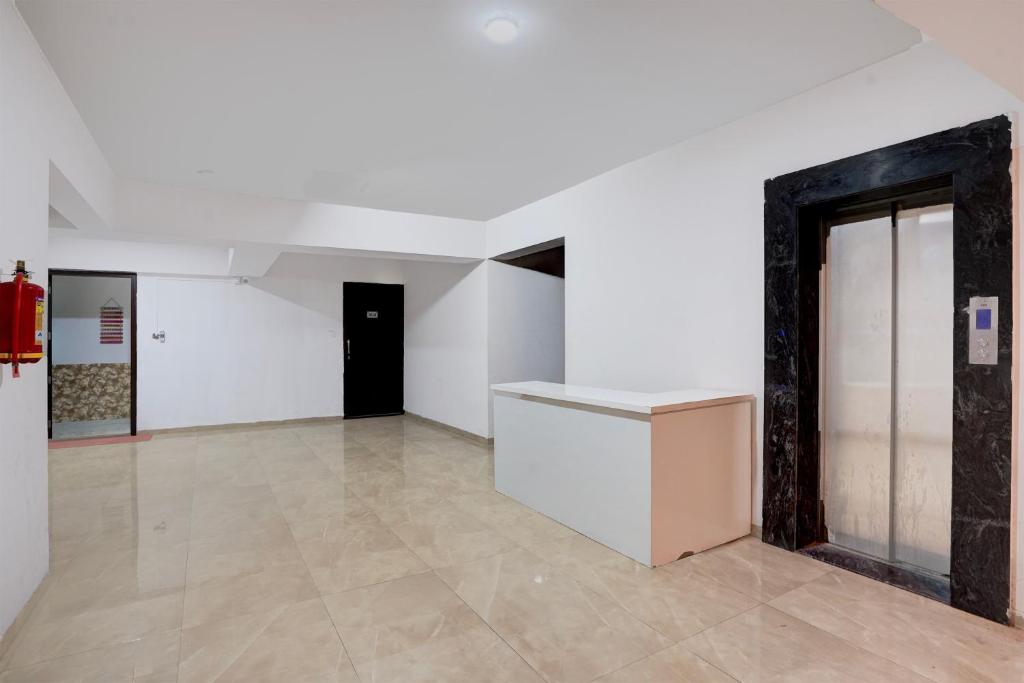 Una habitación vacía con paredes blancas y suelos de baldosas. en Collection O Magarpatta City Formerly Ekab Hospitality, en Mundhwa