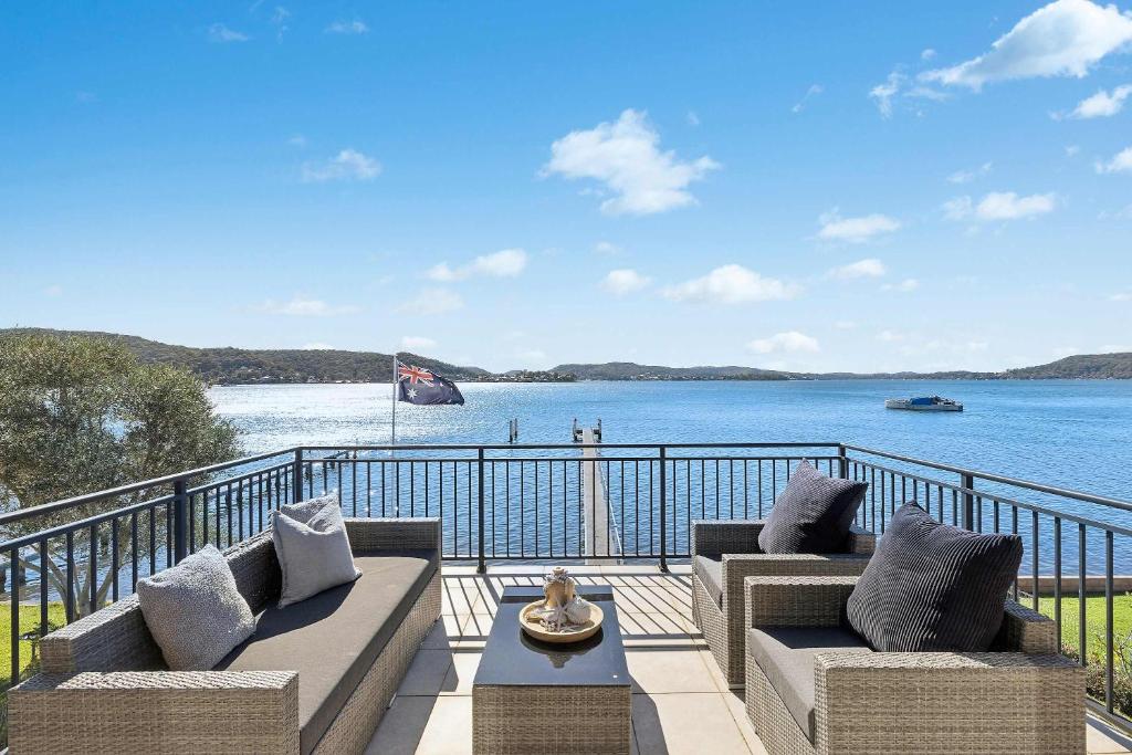 a balcony with two couches and a view of the water at Waters Edge by Coast Hosting in Koolewong