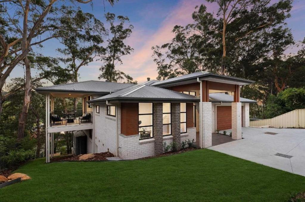 a house with a porch and a grass yard at Ruby Lodge by Coast Hosting in Green Point