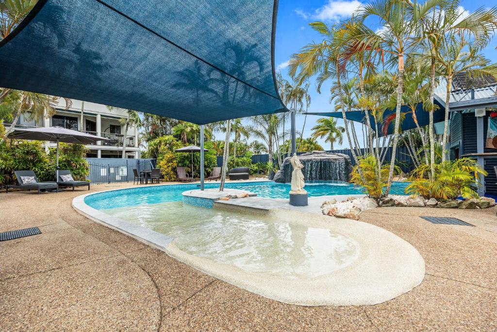 a swimming pool with a fountain in a yard at Grange Resort Hervey Bay in Hervey Bay
