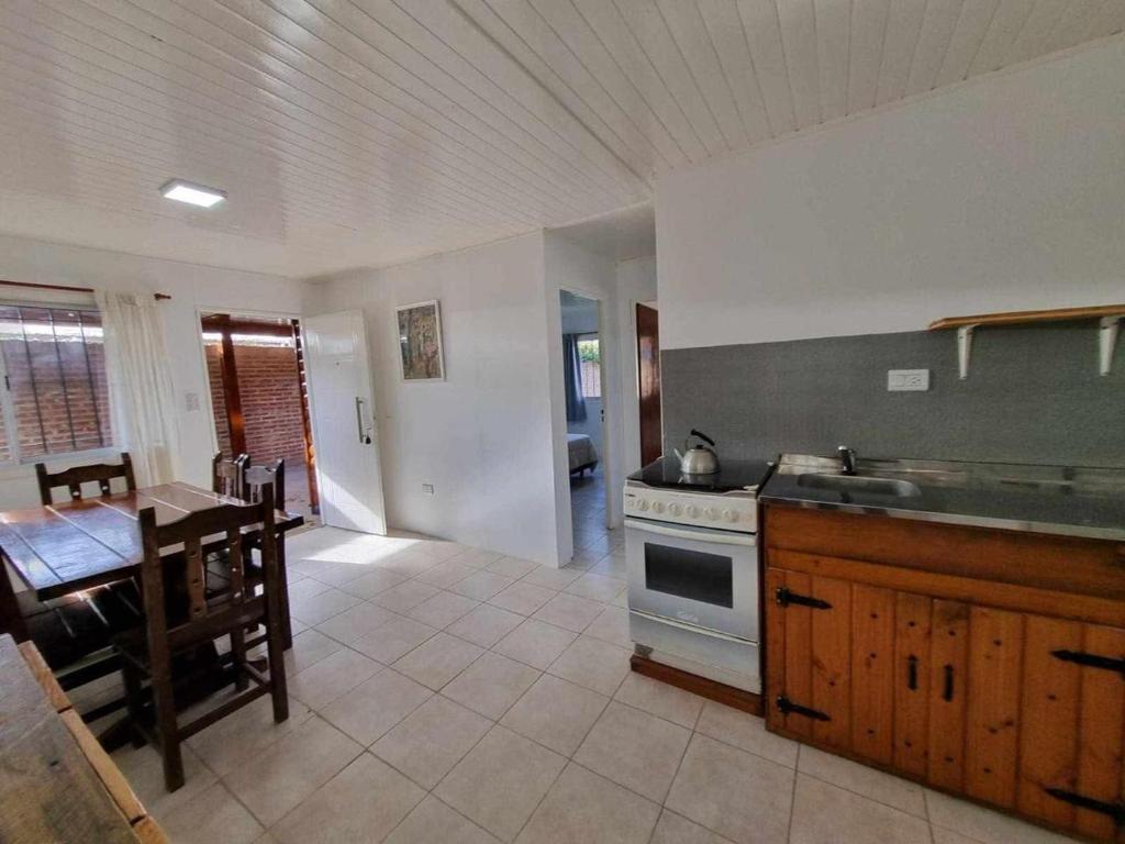een keuken en eetkamer met een tafel en een fornuis bij Cabaña zona vivero in Miramar