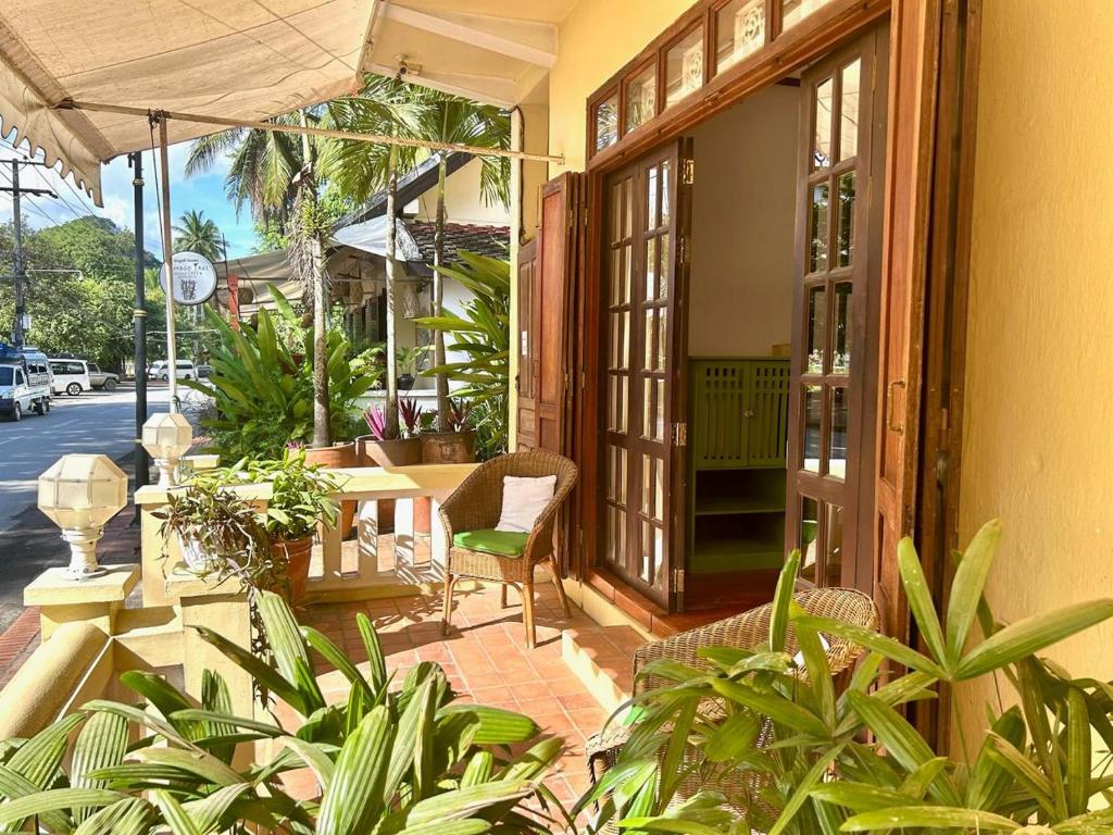 eine Außenterrasse mit einem Tisch, Stühlen und Pflanzen in der Unterkunft Baan Samsa in Luang Prabang