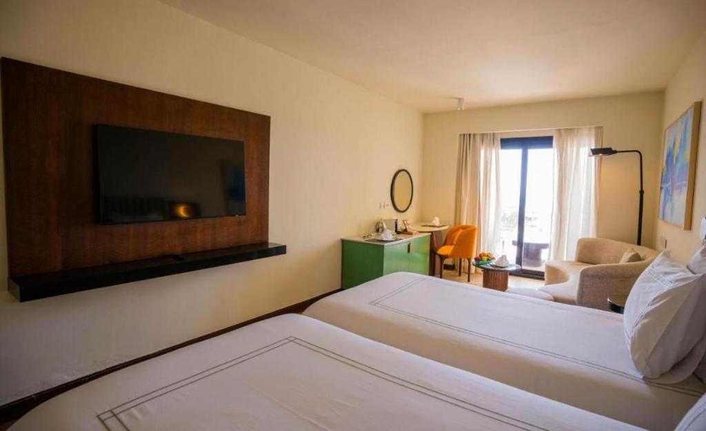 une chambre d'hôtel avec un lit et un salon dans l'établissement Rizkian pyramids view INN, au Caire