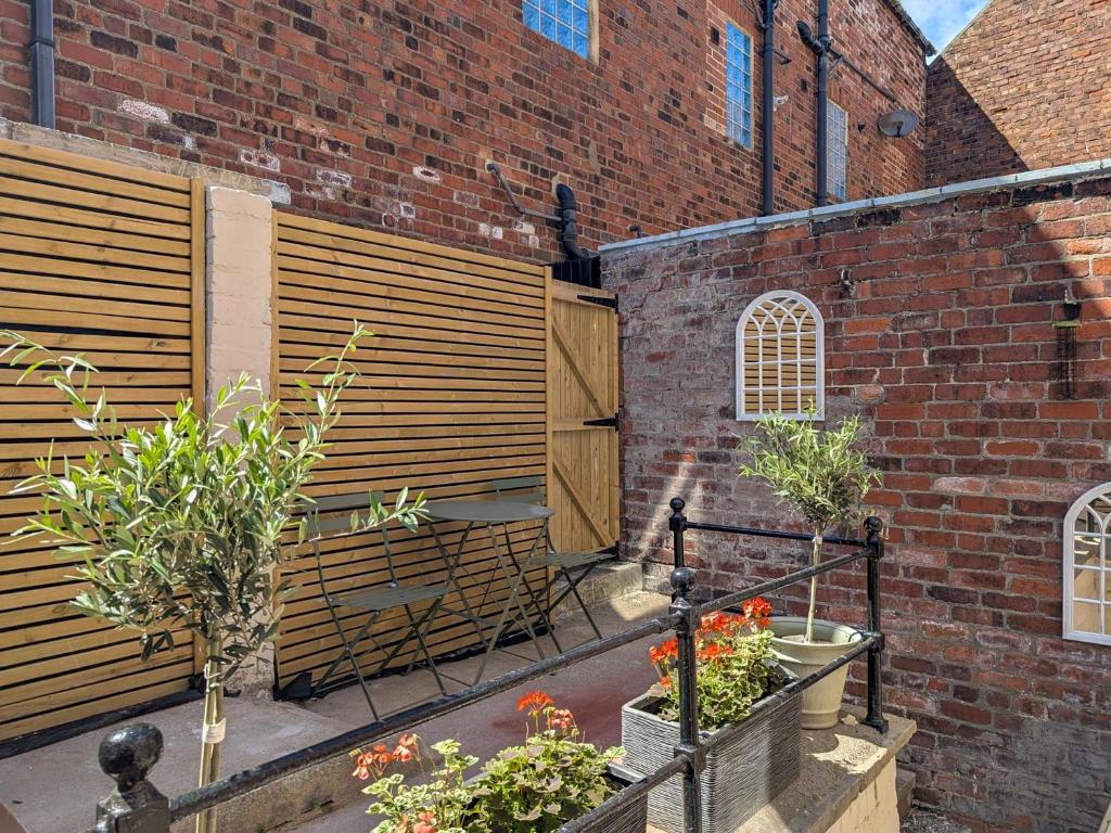 eine Terrasse mit einigen Pflanzen und einer Ziegelmauer in der Unterkunft Botany Bay House in Whitby
