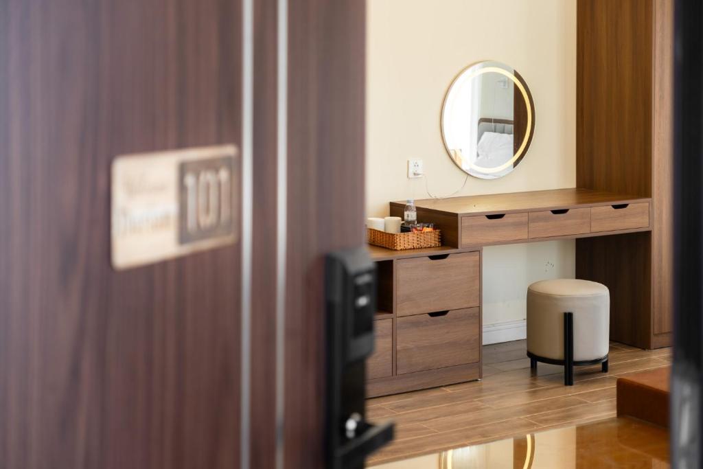 een badkamer met een wastafel met een spiegel en een kruk bij The Moon's House in Mộc Châu