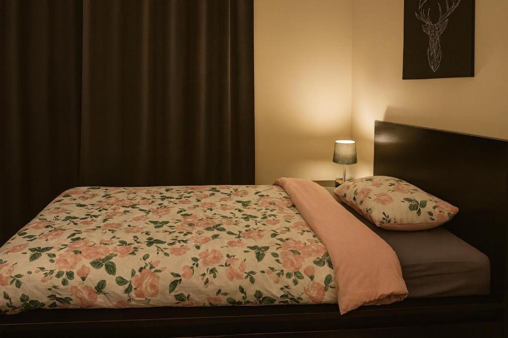 ein Bett mit einer Blumendecke und einem Kissen in der Unterkunft Fresh Trendy apartment in Stockholm