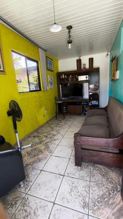 a living room with a couch and a tv at Sobrado há 7 quadras da praia in Matinhos