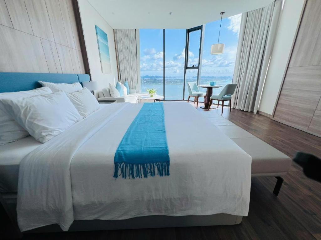 a bedroom with a large bed with a view of the ocean at A LA CARTE Hạ Long Bay View biển tầng cao in Ha Long