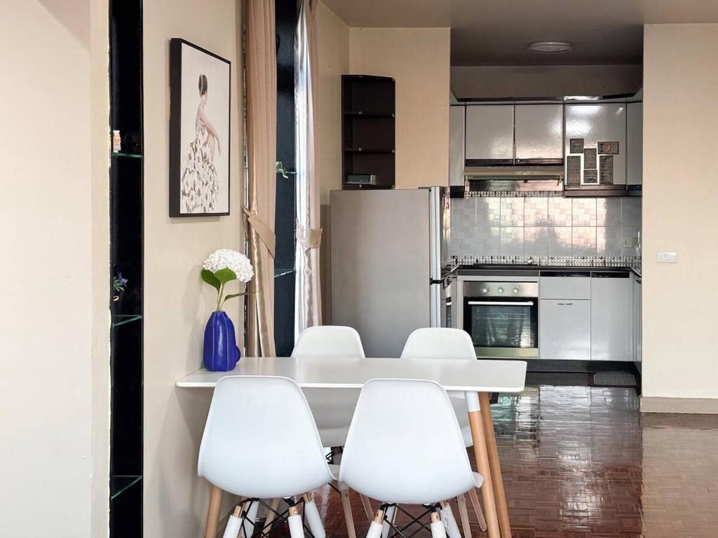 una cucina con un tavolo bianco e sedie bianche di Bann-Kun Impact Muang Thong 2BR Condo Wi-Fi MRT Pink Near Airport DM 
