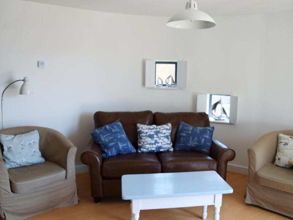 a living room with a couch and two chairs at Sea Drift in West Bay