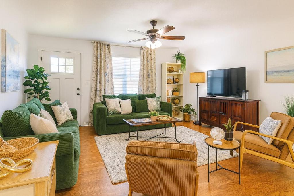 un soggiorno con un divano verde e una TV di The Lagniappe Escape a Marksville