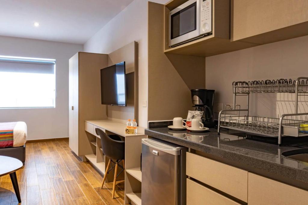 una cucina con un piano di lavoro con un forno a microonde di Hotel Estancias VIVE MX el marques Queretaro, Trademark a Hércules