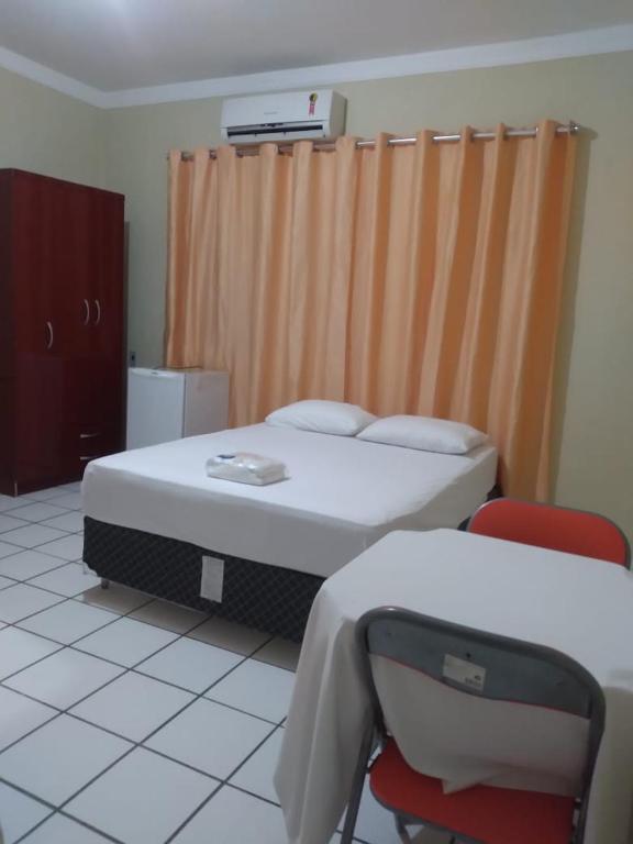 ein Krankenhauszimmer mit einem Bett und einem Stuhl in der Unterkunft Pousada Terra do Sol in Caicó